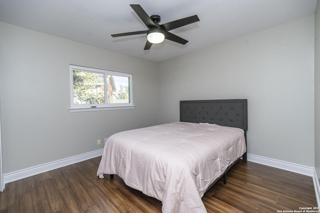 bedroom with ceiling fan, wood finished floors, and baseboards