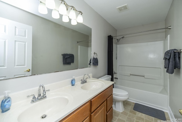 full bathroom featuring toilet, double vanity, a sink, and visible vents