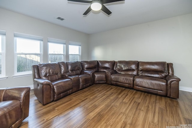 living room with a ceiling fan, baseboards, visible vents, and wood finished floors