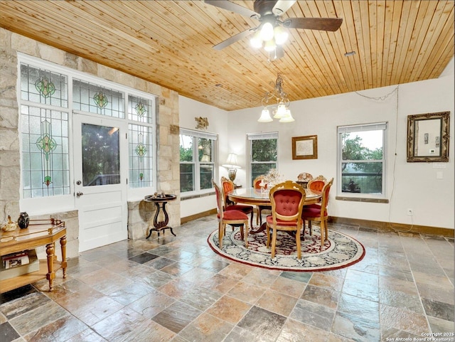 dining area with wooden ceiling, stone tile floors, baseboards, and a wealth of natural light