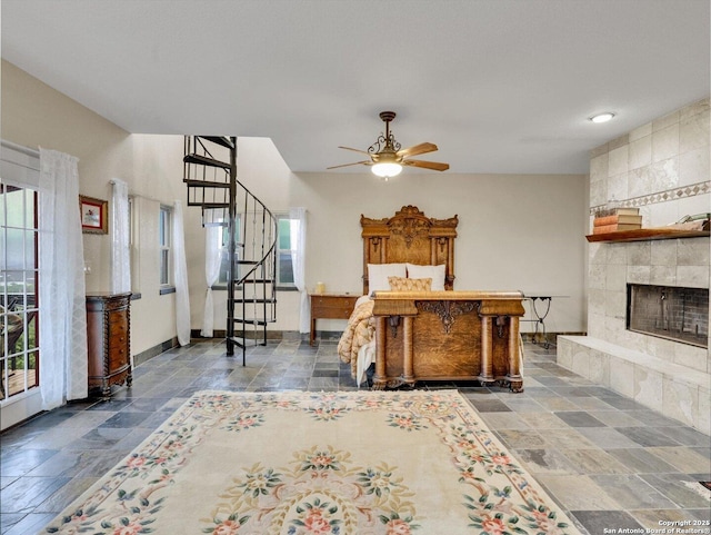 bedroom featuring baseboards, a fireplace, and stone tile floors