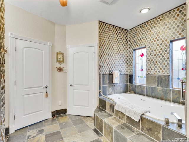 bathroom with stone finish flooring and a garden tub