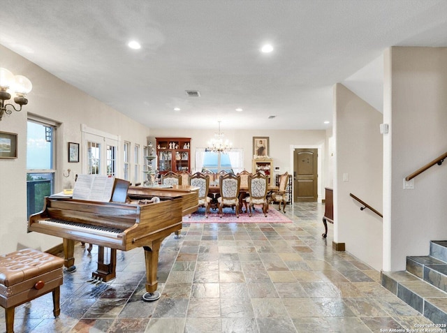 interior space featuring a chandelier, stone tile flooring, stairs, and visible vents