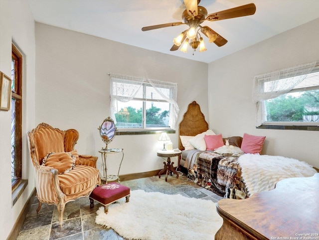 bedroom with multiple windows, ceiling fan, and baseboards