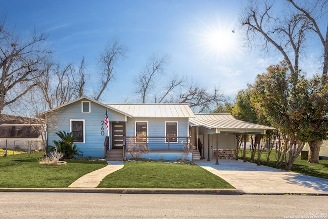 view of front of property with a standing seam roof, fence, concrete driveway, and a front yard