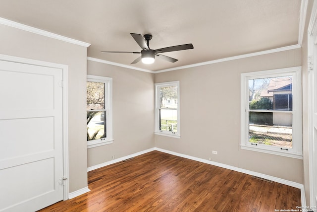 spare room with ceiling fan, ornamental molding, wood finished floors, and baseboards