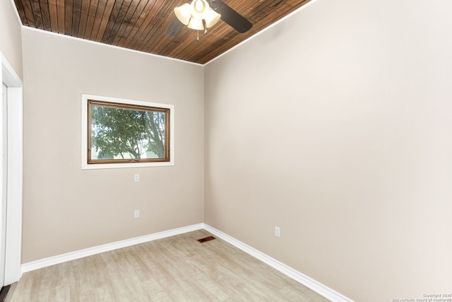 spare room featuring wooden ceiling, a ceiling fan, baseboards, ornamental molding, and light wood-type flooring