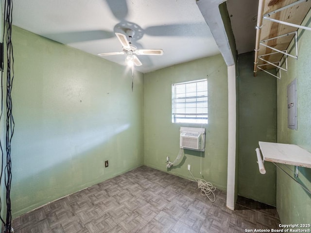 empty room featuring a wall mounted AC, electric panel, and a ceiling fan