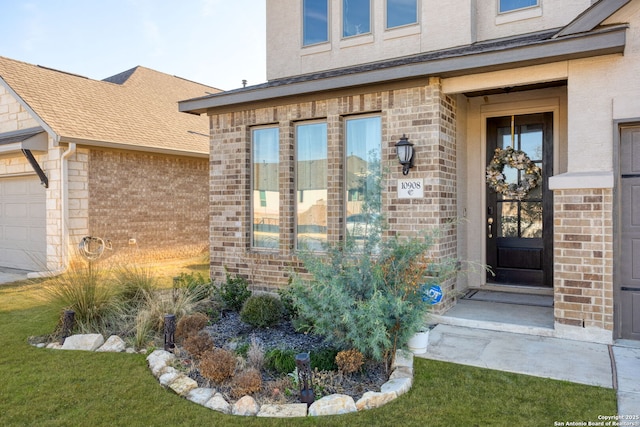 property entrance with a garage, a shingled roof, and brick siding