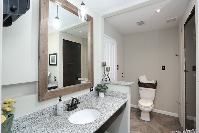 full bath featuring toilet, vanity, visible vents, and baseboards