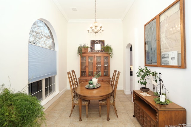 dining room with baseboards, arched walkways, ornamental molding, a notable chandelier, and light tile patterned flooring