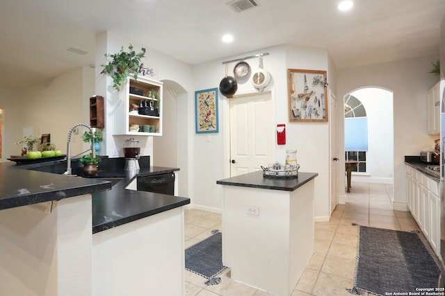 kitchen with arched walkways, open shelves, visible vents, light tile patterned flooring, and dishwasher