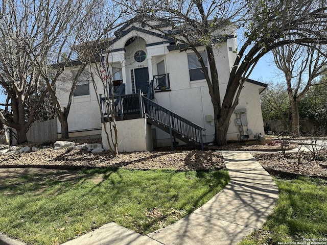 view of front facade featuring a front yard and fence