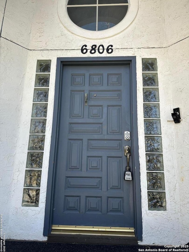 property entrance with stucco siding