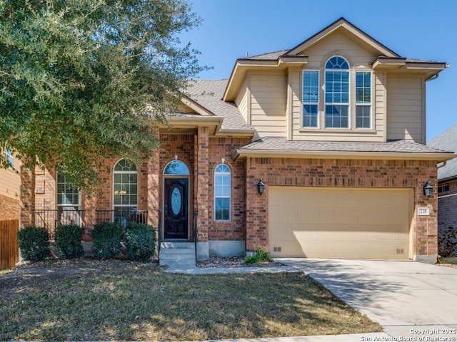 view of front of property with roof with shingles, concrete driveway, a front lawn, a garage, and brick siding