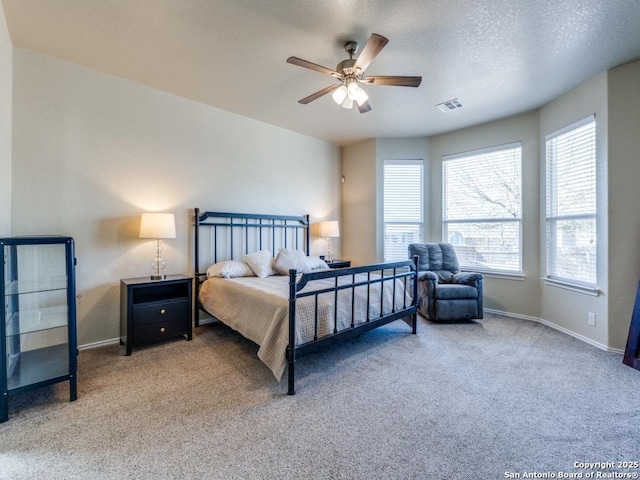 bedroom featuring visible vents, carpet floors, a textured ceiling, and baseboards