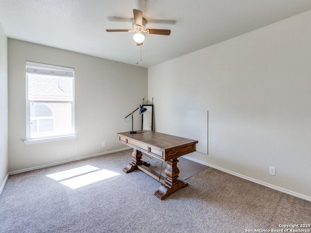 carpeted home office with a ceiling fan and baseboards