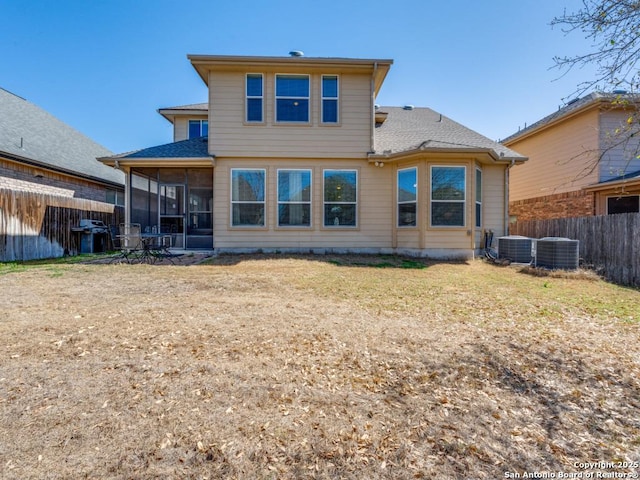 rear view of property with cooling unit, fence, a yard, and a sunroom