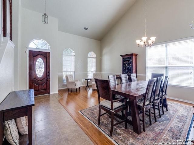 dining room with visible vents, high vaulted ceiling, a healthy amount of sunlight, and an inviting chandelier