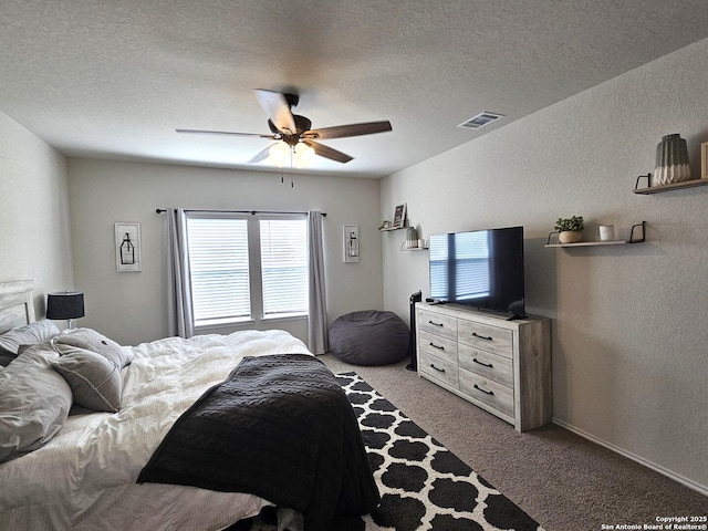 carpeted bedroom featuring a textured ceiling, a textured wall, and visible vents