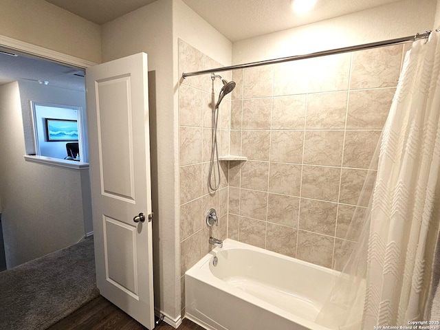 bathroom with shower / tub combo with curtain and wood finished floors