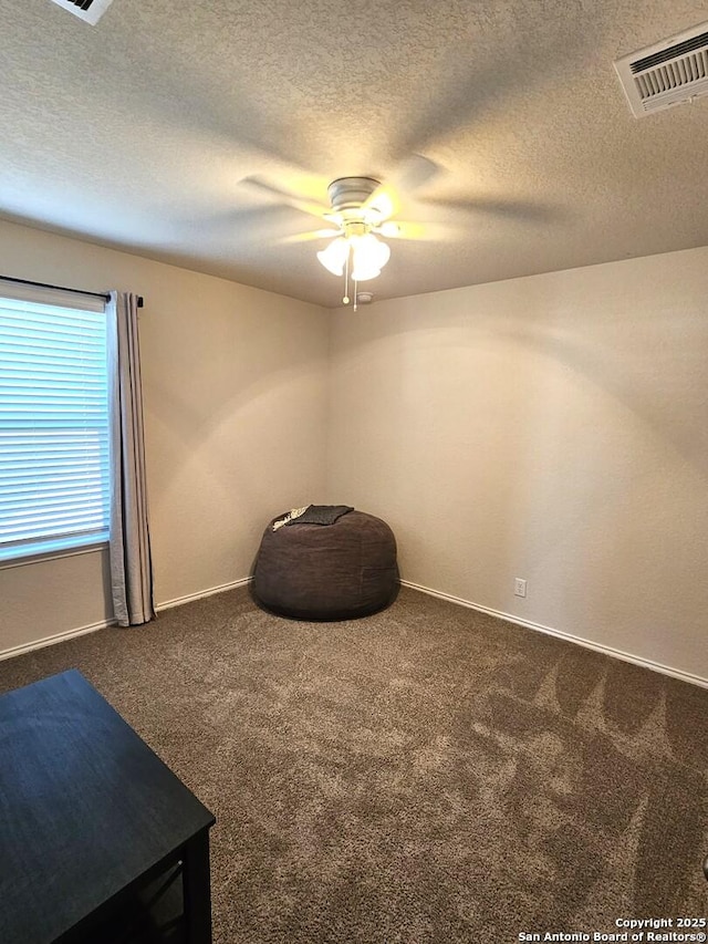 sitting room with ceiling fan, carpet flooring, visible vents, and baseboards