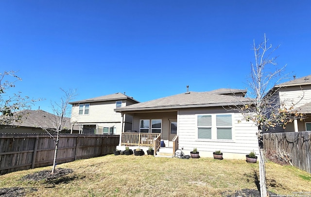 back of house with a fenced backyard and a yard