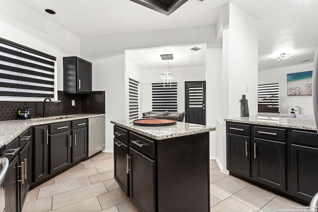 kitchen with tasteful backsplash, visible vents, light stone counters, and dishwasher