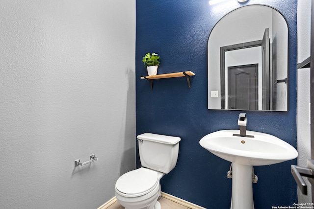 bathroom featuring toilet and baseboards