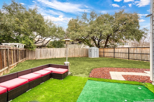 view of yard with an outbuilding, a shed, outdoor lounge area, and a fenced backyard