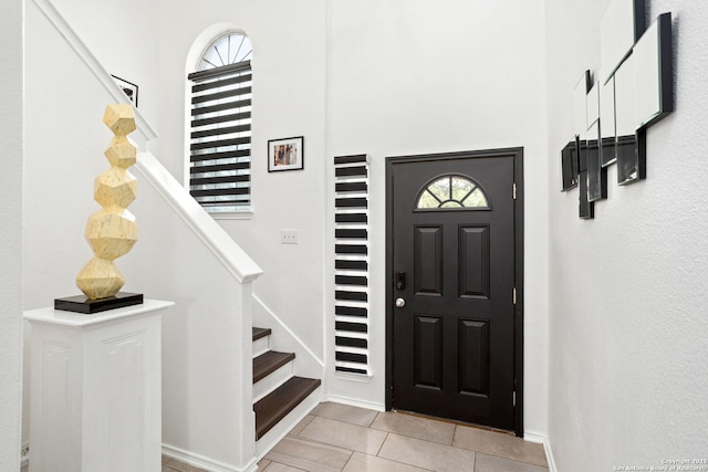 entrance foyer with light tile patterned floors and stairs