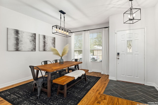 dining area featuring baseboards and dark wood-type flooring