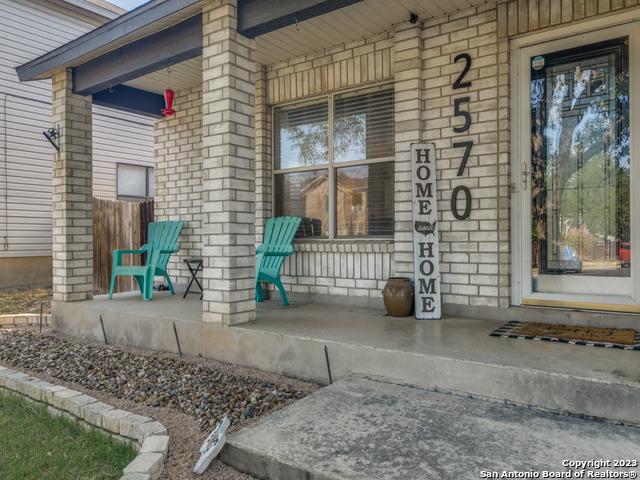 entrance to property featuring a porch and brick siding