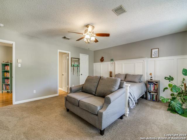 bedroom with light carpet, visible vents, and a textured ceiling