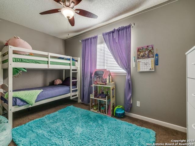 carpeted bedroom with a textured ceiling, ceiling fan, and baseboards