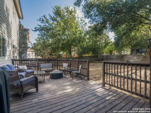 wooden terrace with fence and an outdoor living space