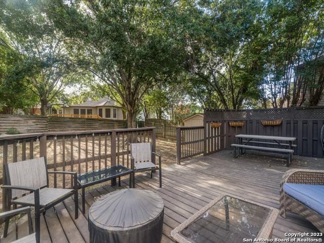 wooden terrace featuring a fenced backyard and area for grilling