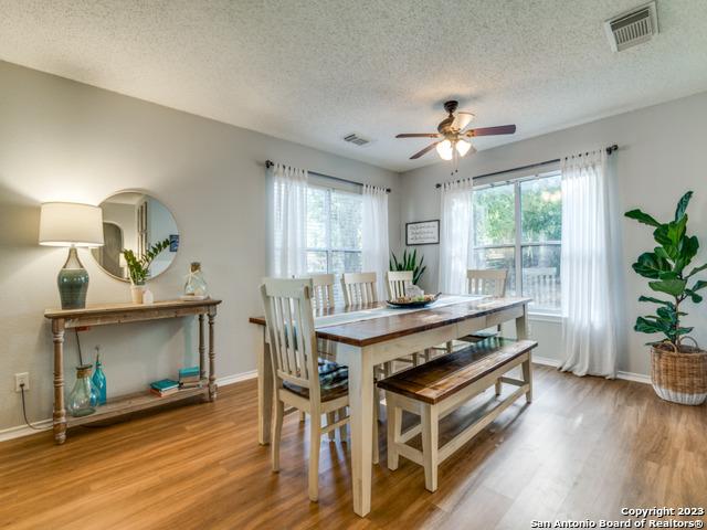 dining room featuring a wealth of natural light, wood finished floors, visible vents, and baseboards