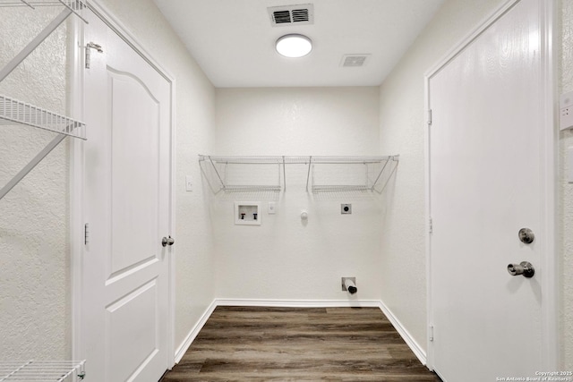 washroom with hookup for a gas dryer, visible vents, dark wood-type flooring, electric dryer hookup, and laundry area