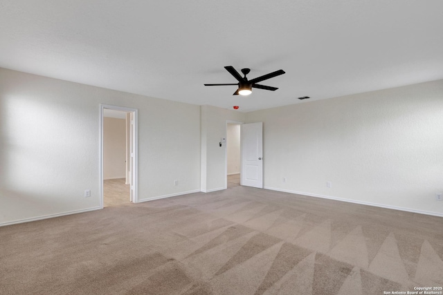 carpeted spare room featuring visible vents, ceiling fan, and baseboards