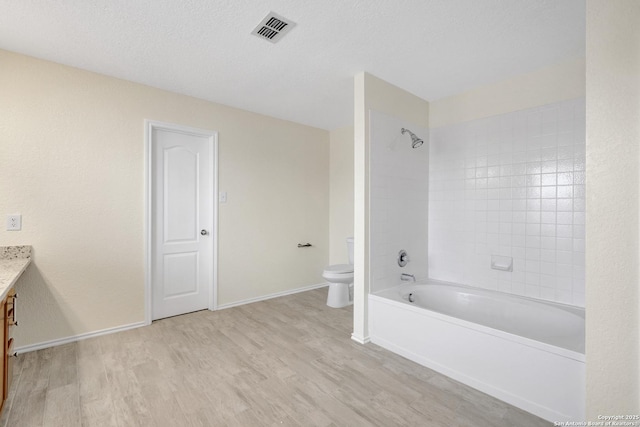 bathroom featuring visible vents, toilet, wood finished floors, a textured ceiling, and vanity