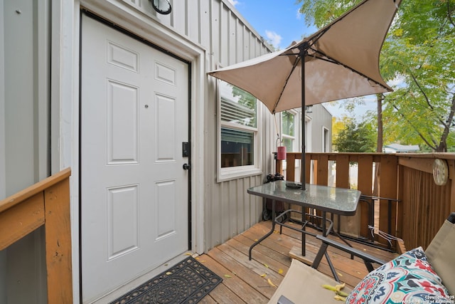 doorway to property featuring board and batten siding and a wooden deck