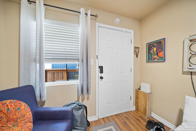 entrance foyer with baseboards and wood finished floors