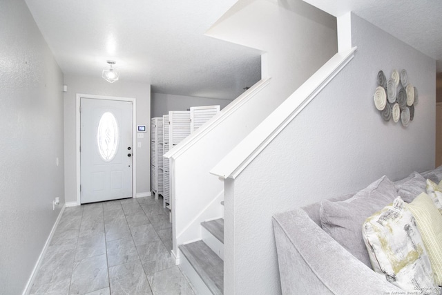 entrance foyer featuring baseboards and stairway