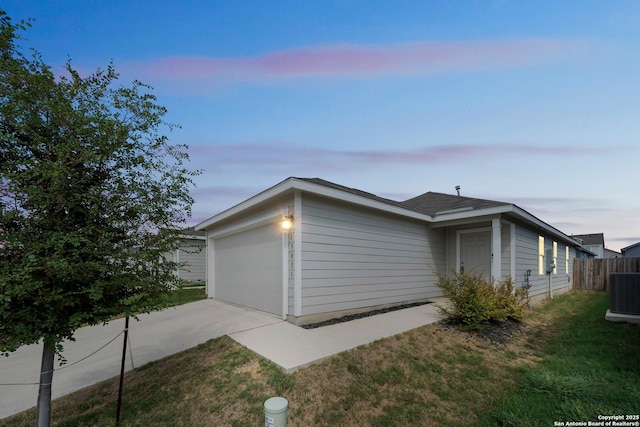 view of home's exterior featuring a yard, an attached garage, central AC unit, fence, and driveway