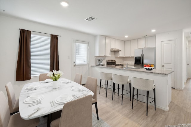 dining space featuring light wood-type flooring, visible vents, and recessed lighting