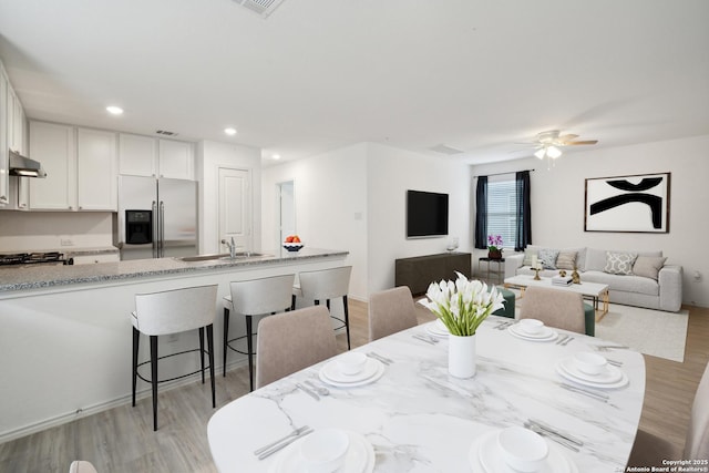 dining area featuring light wood-type flooring, a ceiling fan, and recessed lighting