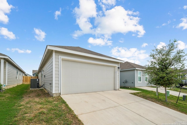 view of front of property with a detached garage, fence, cooling unit, and a front yard