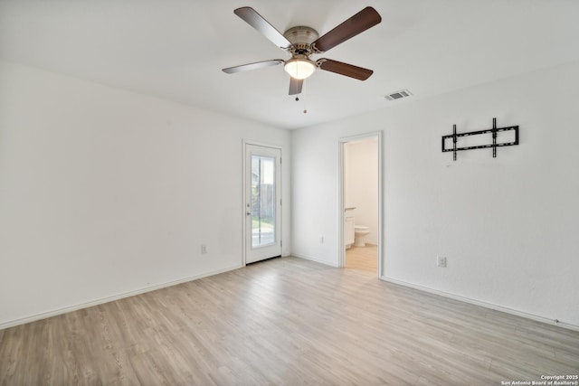 spare room featuring light wood-type flooring, visible vents, ceiling fan, and baseboards