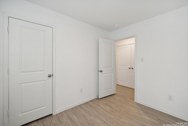 unfurnished bedroom with light wood-type flooring and baseboards